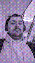 a selfie of a white person, wearing either headphones or a helmet, making an odd expression. the photo is edited to be colorized into a monochrome purple-ish color palette.
